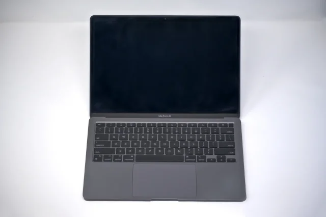 Открытый MacBook Air с тёмным экраном на светлом фоне