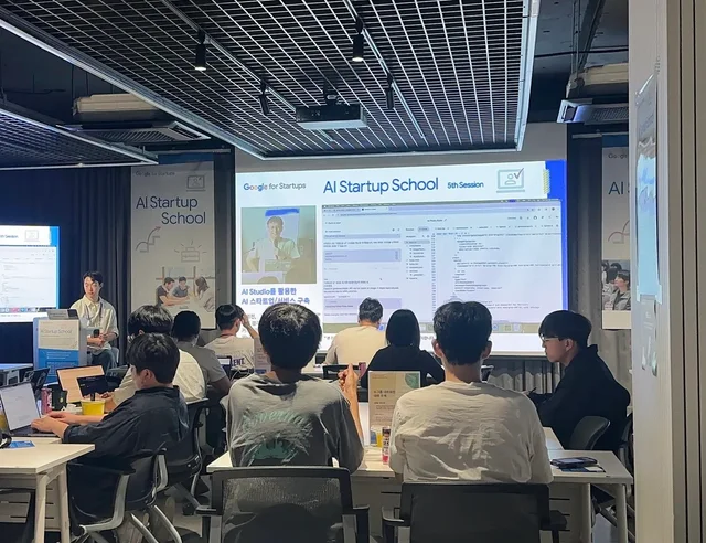 Участники очного занятия Google for Startups AI Startup School работают за ноутбуками перед экраном с учебным материалом по ИИ