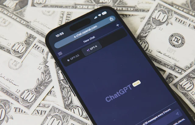 Смартфон с архивной версией ChatGPT на фоне долларовых банкнот